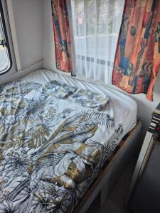 a bed sitting in a room with a window at Caravane dans les Cévennes in Saint-Germain-de-Calberte