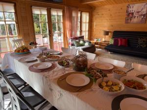 ein Tisch mit Tellern und Schüsseln voller Essen in der Unterkunft Ramus Ūkis in Jakiškiai + 31 Fotos