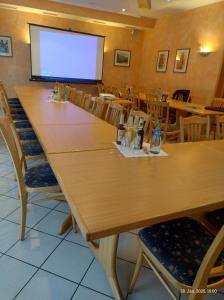 a conference room with a large table and a screen at Gasthaus Linde Ingelfingen in Ingelfingen