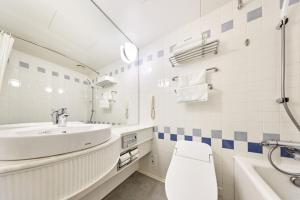 a white bathroom with a sink and a toilet at Hotel Nikko Northland Obihiro in Obihiro +72 photos