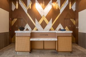 a reception counter in a lobby with a mural at Belmont Hotel Iloilo in Iloilo City