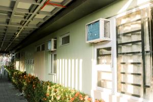 a green building with a window and an air conditioner at CELCOR PENSION HOUSE in Cabatuan