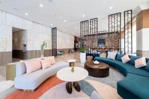 a lobby with blue and white couches and tables at Belmont Hotel Iloilo in Iloilo City