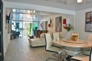een eetkamer en een woonkamer met een tafel en stoelen bij La Romantica in Contadora