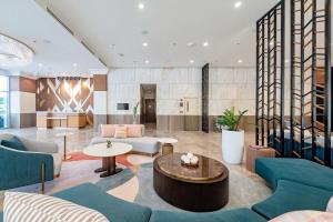 a lobby with blue chairs and a table at Belmont Hotel Iloilo in Iloilo City