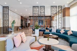 a lobby with a blue couch and tables at Belmont Hotel Iloilo in Iloilo City +39 photos