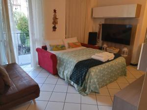 a bedroom with a bed with a television and a couch at casa raffa megaride's dépendance in Como