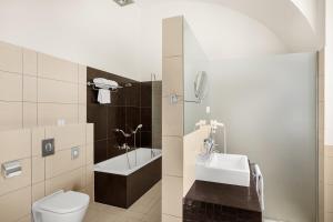 a bathroom with a toilet and a sink at Buda Castle Hotel Budapest in Budapest