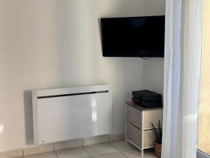 a room with a flat screen tv on a wall at T2 POMPERTUZAT Calme avec parking in Pompertuzat