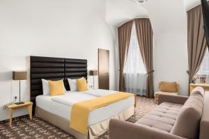 a hotel room with a bed and a couch at Buda Castle Hotel Budapest in Budapest
