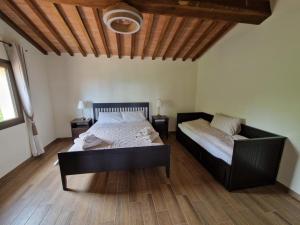 a bedroom with a bed and a couch at Casa Lori in Fauglia