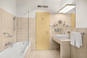 a bathroom with a tub and a sink and a shower at Buda Castle Hotel Budapest in Budapest