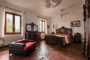 a bedroom with a bed and a chair and a mirror at Podere Magnolia in Pisa