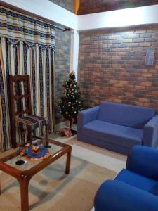 sala de estar con sofá azul y árbol de Navidad en Casa De Los Colores, en Paipa