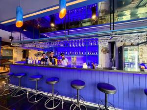 a bar with blue bar stools in a restaurant at Blue Neptuna Hotel Patong in Patong Beach +5 photos