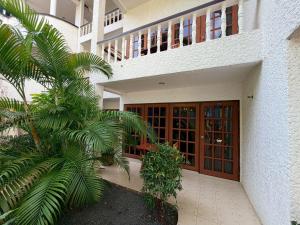a building with a door and a palm tree at Blue Neptuna Hotel Patong in Patong Beach