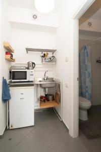 a small kitchen with a microwave and a sink at Assuta studio in Tel Aviv