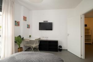 a bedroom with a bed and a tv on the wall at Assuta studio in Tel Aviv