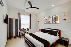 a bedroom with a bed with a ceiling fan at Super Townhouse by OYO Cosmo Mall Zirakpur Formerly R K Residency in Zirakpur