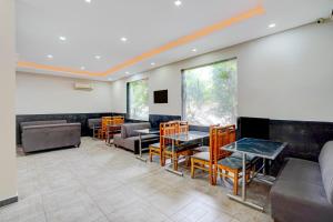 a waiting room with tables and chairs and windows at Super Townhouse by OYO Cosmo Mall Zirakpur Formerly R K Residency in Zirakpur