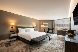 a hotel room with a bed and a desk at PARKROYAL Parramatta in Sydney +23 photos