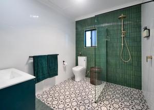 a bathroom with a shower and a toilet and a sink at Malanda Falls Retreat in Malanda