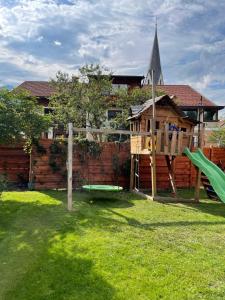 ein Spielplatz mit Rutsche und Spielhaus in der Unterkunft Alprocks Alvaresort in Bichlbach