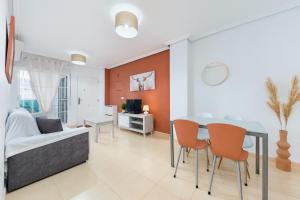 a living room with a table and chairs and a couch at Playa del Pinet 2 in La Marina +16 photos