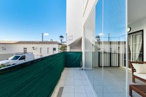 a balcony with a green fence and a white car at Playa del Pinet 2 in La Marina
