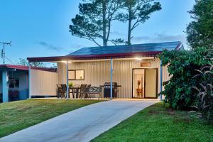 a small house with a patio and a table at Malanda Falls Retreat in Malanda