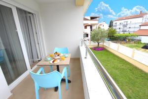 a balcony with blue chairs and a table on a balcony at Studio Emanuel in Rovinj
