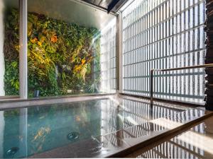 an indoor swimming pool with a view of a garden at Hotel Oak Shizuoka in Shizuoka