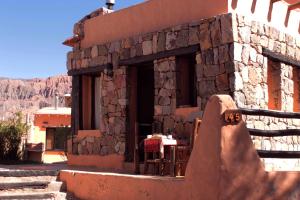 a stone building with a table and a table at Piedramora Tilcara in Tilcara