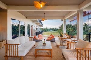 a porch with couches and tables and windows at Serene Park Hotel By Ark in Tissamaharama