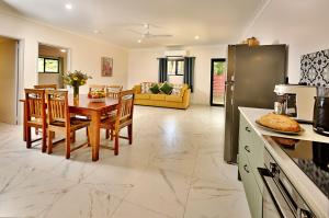 a kitchen and living room with a table and chairs at Malanda Falls Retreat in Malanda +38 photos
