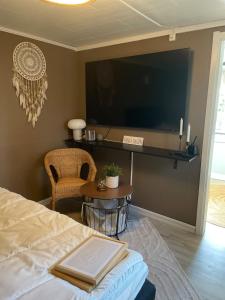 a bedroom with a bed and a tv and a table at Guesthouse Holmen in Färgelanda