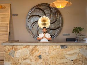 a man standing behind a counter with a brass instrument at Serene Park Hotel By Ark in Tissamaharama +70 photos