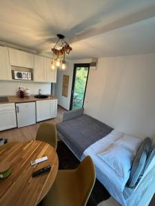 a bedroom with a bed and a table in it at Tiny Cozia Caciulata in Caciulata