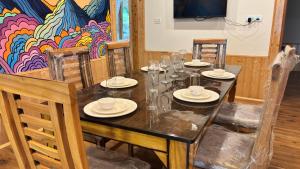 a dining room with a table with glasses and chairs at Akari Inn in Haripūr