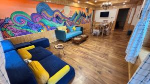 a living room with a blue couch and a colorful wall at Akari Inn in Haripūr