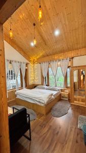 a bedroom with a large bed in a wooden room at Akari Inn in Haripūr
