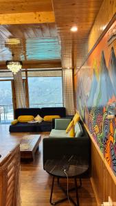 a living room with a couch and a painting on the wall at Akari Inn in Haripūr