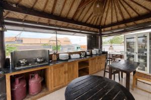 a kitchen with a counter and a table and chairs at Tendan Residence in Legian
