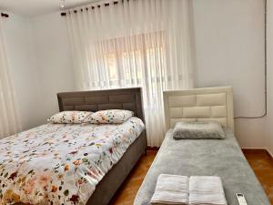 a bedroom with a bed and a window at Double Triple Rooms With Lake View balcony in Pogradec