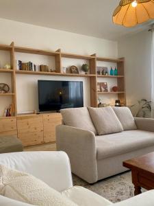 a living room with a couch and a flat screen tv at Maison de vacances, centre ville Gambetta in La Teste-de-Buch