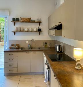 a kitchen with a sink and a counter with a lamp at Maison de vacances, centre ville Gambetta in La Teste-de-Buch
