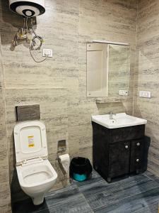a bathroom with a toilet and a sink and a mirror at Tirthan Villa Homestay in Banjār +28 photos