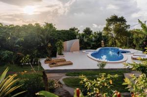 a pool in the middle of a yard with chairs and trees at Manigelang Villa in Munduk