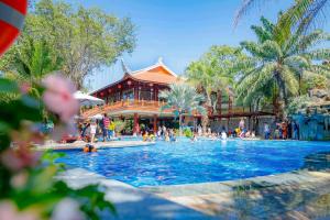 a large swimming pool in front of a resort at Phuong Nam Resort in Thuan An