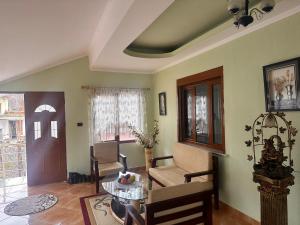 a living room with a table and a chair at Double Triple Rooms With Lake View balcony in Pogradec